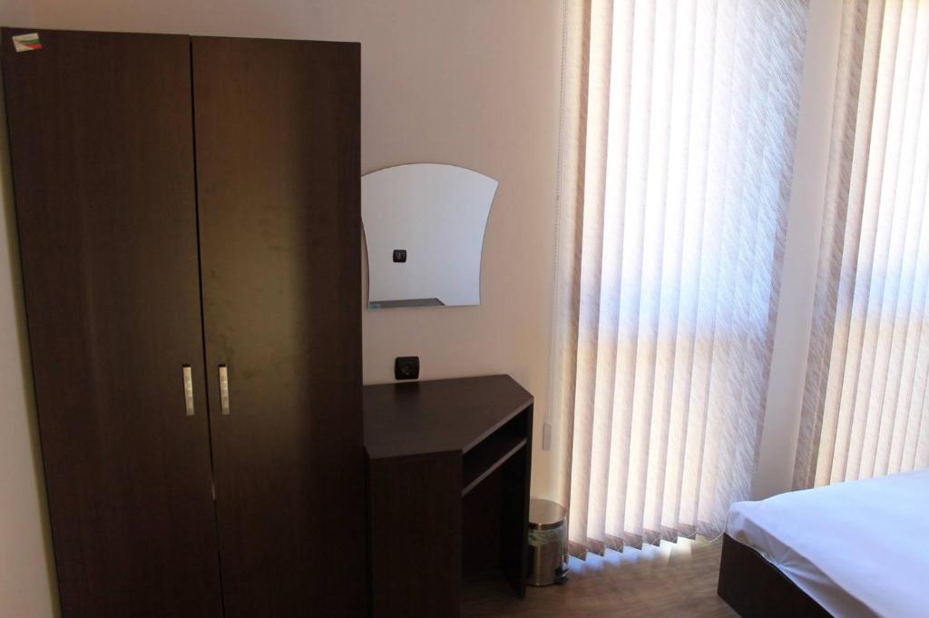 um quarto com uma cómoda preta e um armário em Къща за гости Българи em Triavna