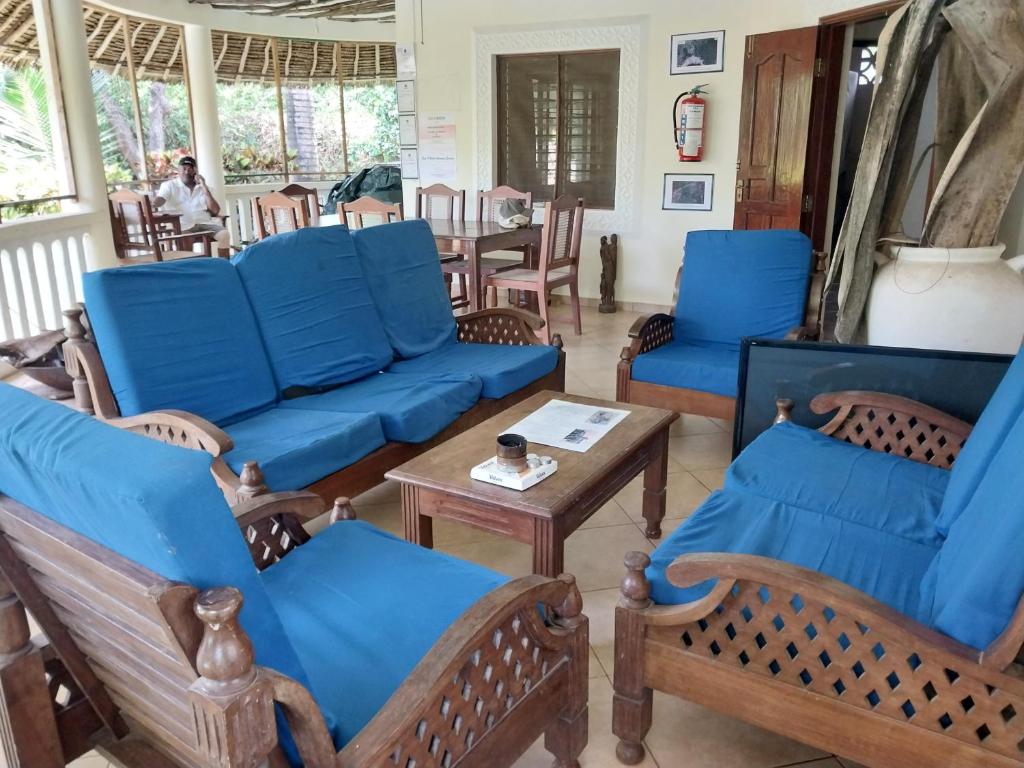 ein Wohnzimmer mit blauen Sofas und einem Tisch in der Unterkunft Dosi lounge in Ukunda