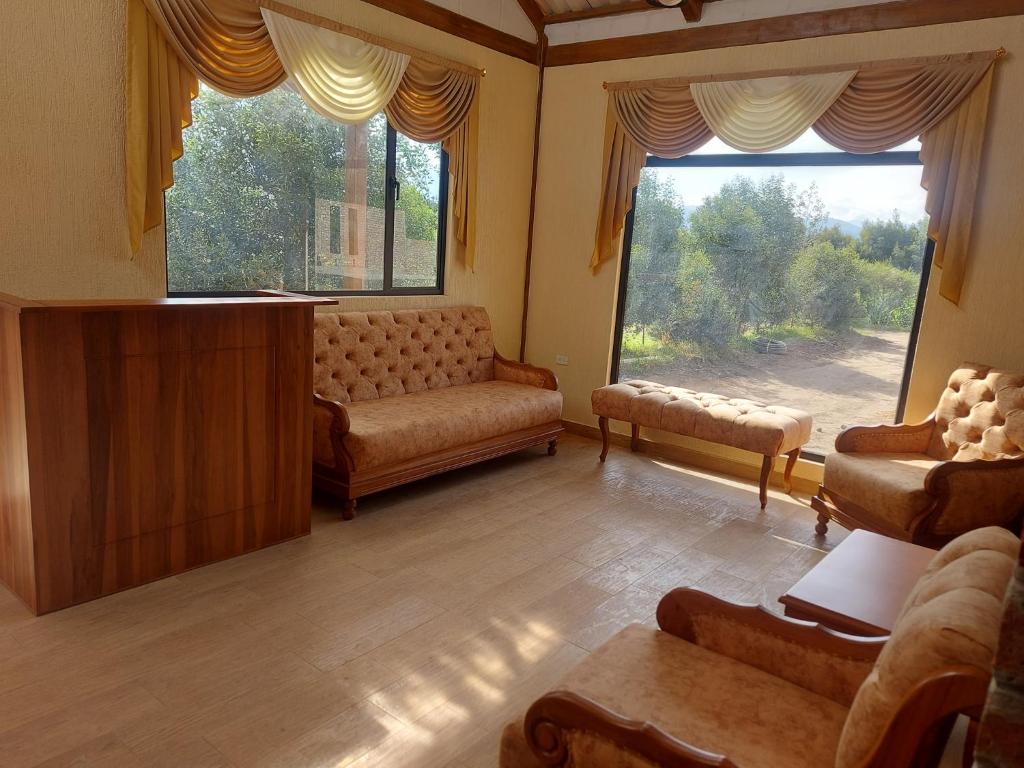sala de estar con sofá y ventana grande en HOSTERÍA QUINTA INÉS MARÍA en Chambo