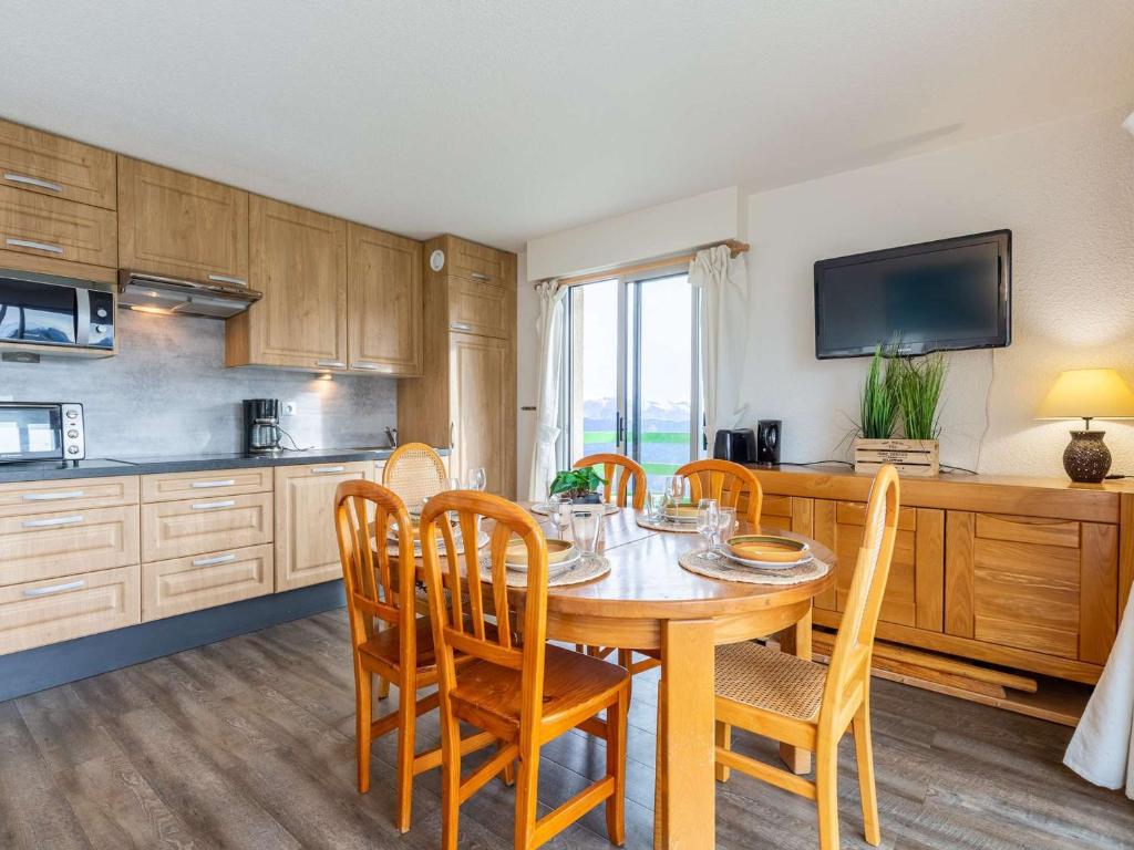 une salle à manger avec une table et des chaises et une cuisine dans l'établissement Bel appartement 8/10 pers. proche pistes à Saint-Lary-Soulan - FR-1-296-490, à Saint-Lary-Soulan