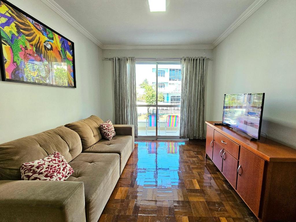 a living room with a couch and a flat screen tv at Apt Centro de Foz, para até 8 pessoas com garagem in Foz do Iguaçu