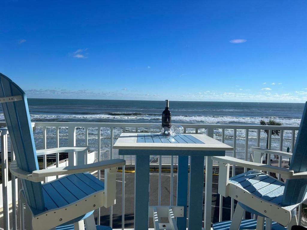 a table and chairs on a balcony with the ocean at Ocean Pool King Bed in Daytona Beach