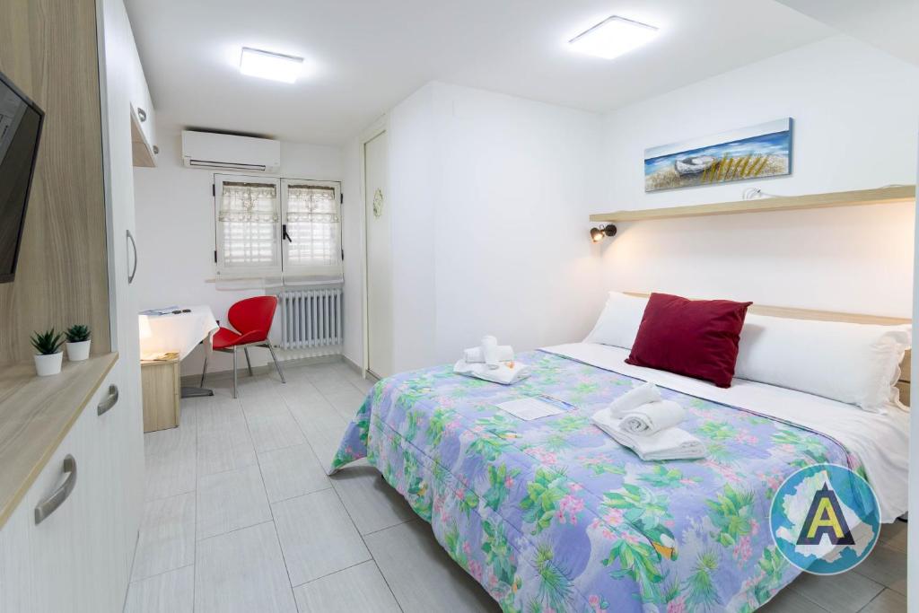 a bedroom with a large bed and a red chair at Casa Arcobaleno 57p in Pescara