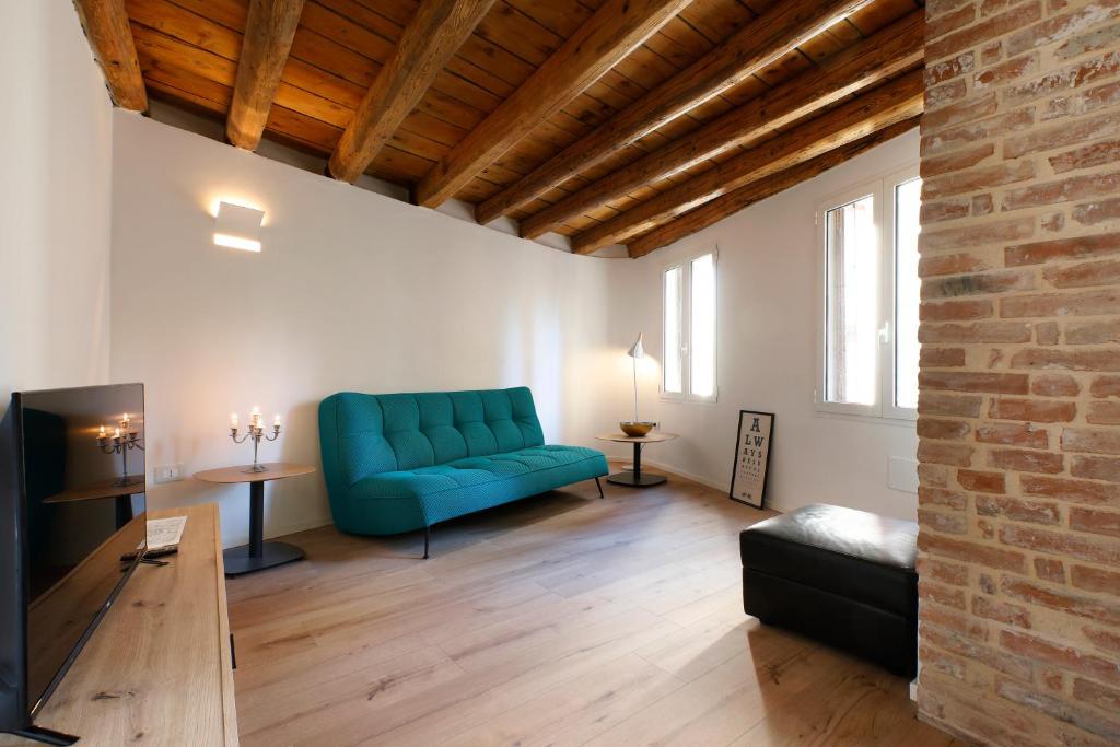 sala de estar con sofá azul y pared de ladrillo en 25 Lazzaro Bonamigo en Bassano del Grappa