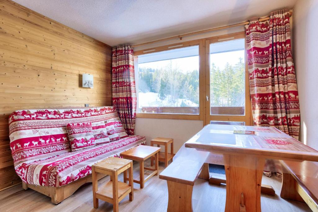 ein Wohnzimmer mit einem Sofa und einem Tisch in der Unterkunft Les Résidences de Valmorel - maeva Home - 2 Pièces 4 Personnes Confort 58 in Valmorel