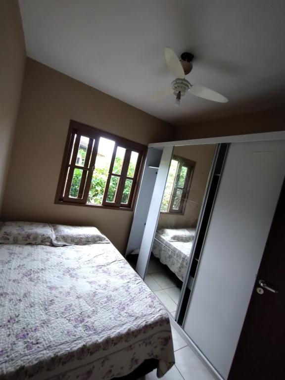 una camera con letto e specchio di Casa de praia a Florianópolis