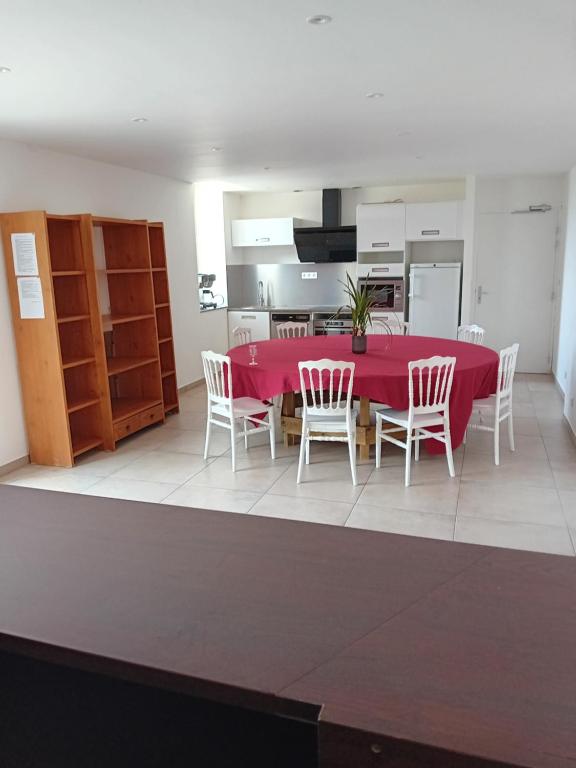 a dining room with a red table and chairs at Domaine de kerbillec in Theix