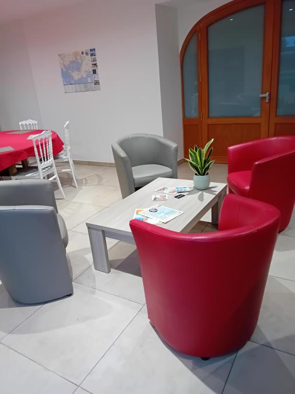 a dining room with red chairs and a table at Domaine de kerbillec in Theix