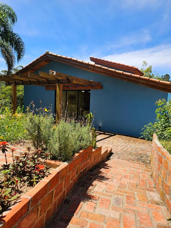 een blauw huis met een bakstenen pad ervoor bij Cabana do Rancho Roque Reis - Wine and Nature in Piedade