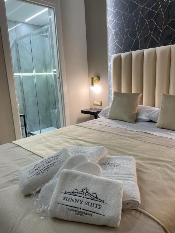 una camera da letto con un letto e asciugamani di Sunny Suite Napoli a Napoli