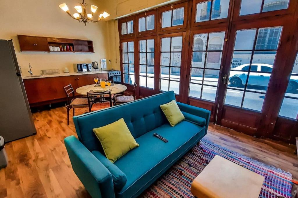 - un salon avec un canapé bleu et une table dans l'établissement The Wall Montevideo [003] Loft in the Old Town, à Montevideo