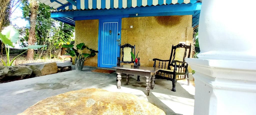 a patio with a table and chairs and a blue door at Selnara Private Luxury Villa and Ayurveda Spa in Bentota