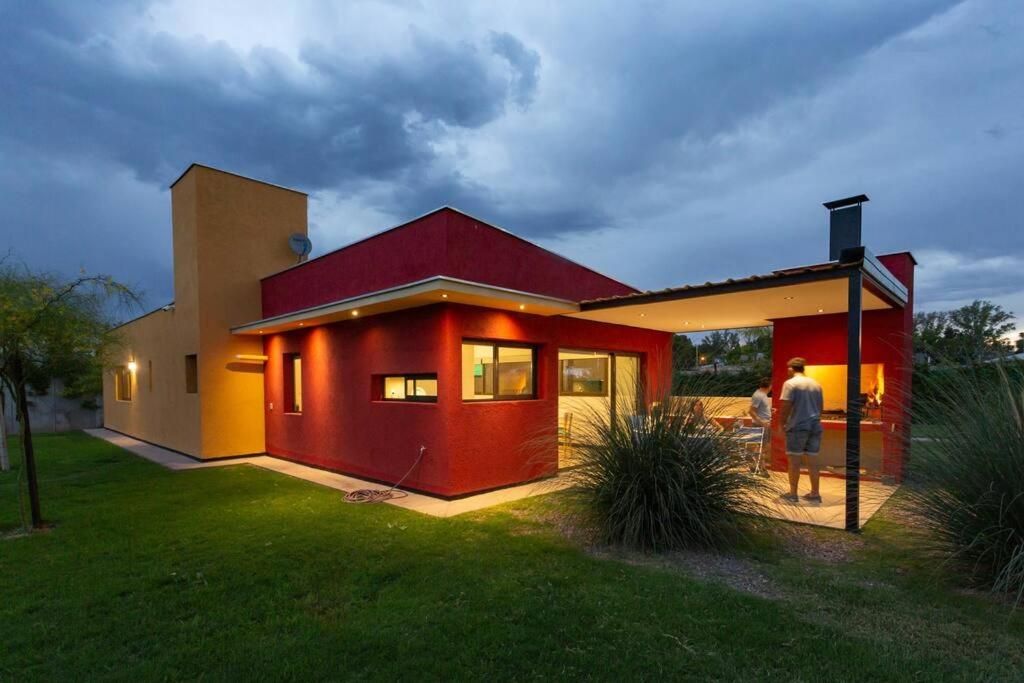 a man and woman standing outside of a house at Estancia Yolanda C1 - by Inside in Ciudad Lujan de Cuyo