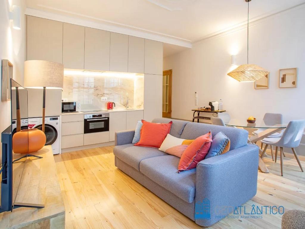 een woonkamer met een blauwe bank en een keuken bij Porto Almada Design Loft in Porto