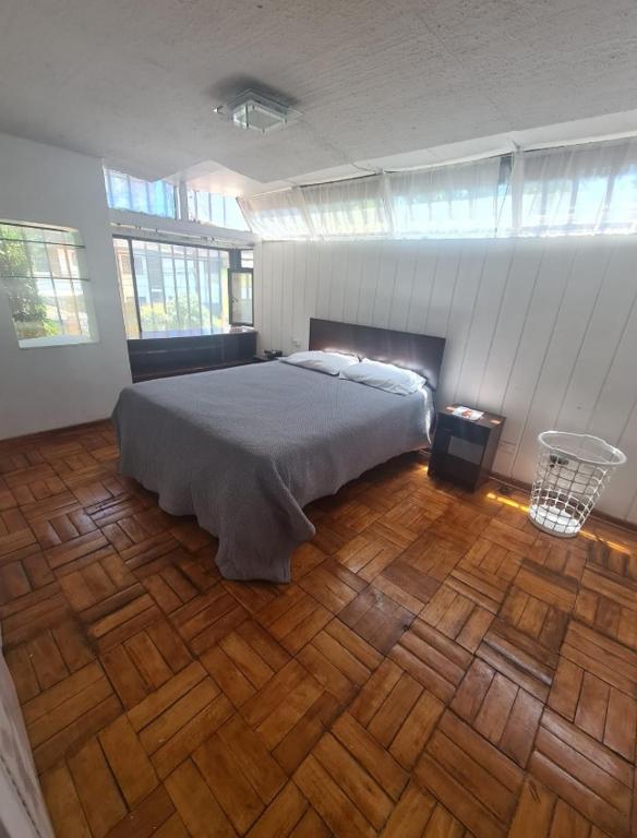 a bedroom with a bed and a wooden floor at Las condes, Amplia habitación con baño privado in Santiago