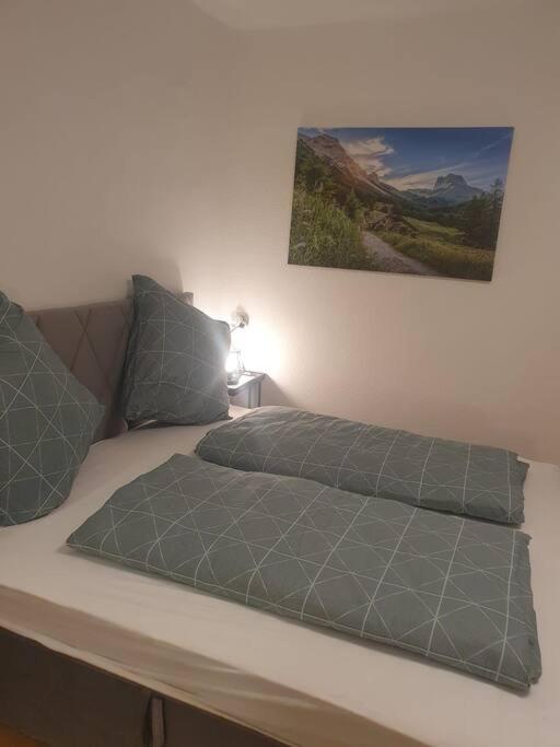 uma cama com duas almofadas e uma fotografia na parede em ST4 Apartment em Triberg