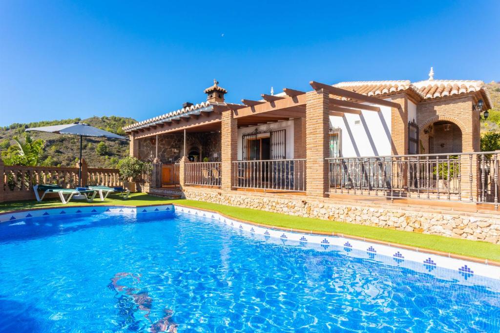 a villa with a swimming pool in front of a house at Villa Bonifacio in Maro