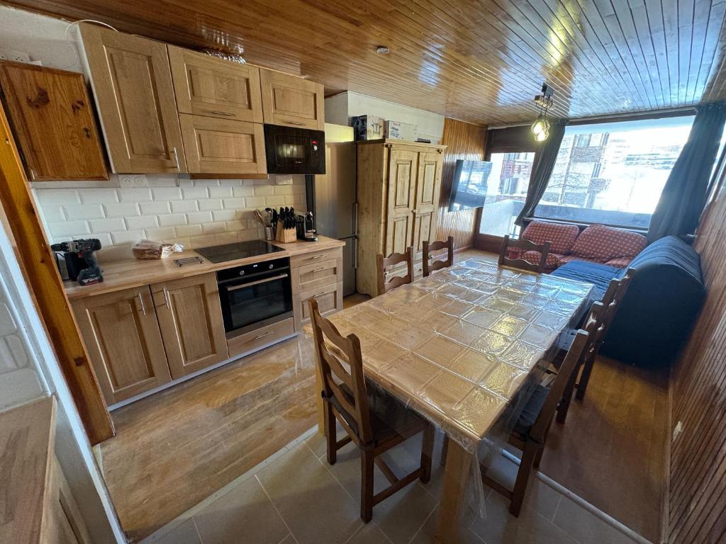a kitchen with a table and chairs in a room at Appartement Tignes - Quartier Calme - 2 chambres - 3 Télévisions - Netflix & Wifi inclus in Tignes