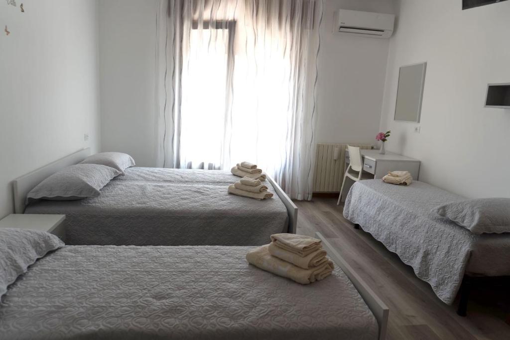 a bedroom with three beds with towels on them at BnB Martin in Jesolo