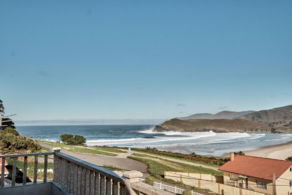 a view of a beach with a house and the ocean at Pantin Beach&Surf in Valdoviño