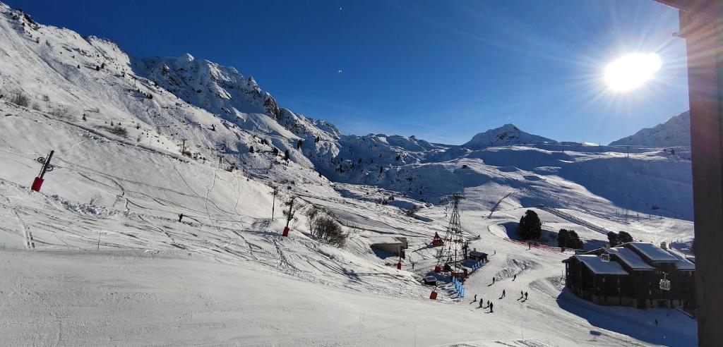 a snow covered mountain with people on a ski lift at Bel appartement rénové à Belle Plagne in Belle Plagne