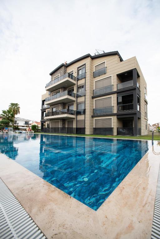 a swimming pool in front of a building at Living Dream Apartment DUPLEX BELEK in Belek