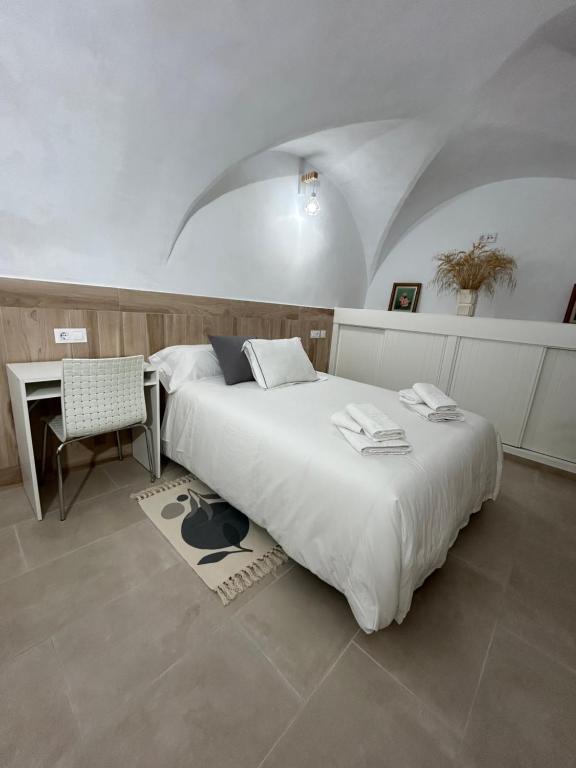 1 dormitorio con 2 camas, mesa y silla en Casa Abuelo Miguel, en Arcos de la Frontera
