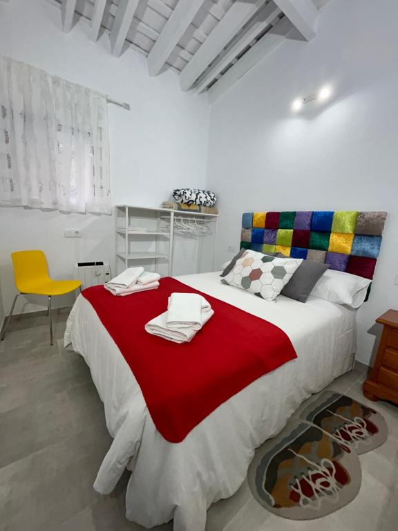 ein Schlafzimmer mit einem großen Bett mit einer roten Decke in der Unterkunft Casa Abuela María in Arcos de la Frontera