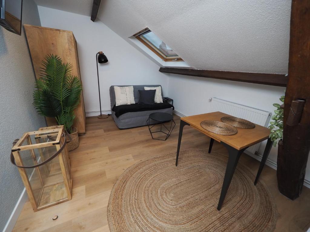 ein Wohnzimmer mit einem Tisch und einem Sofa in der Unterkunft Appartement meublé 5 - 15 min Dampierre - 25 min Belleville - WIFI in Gien