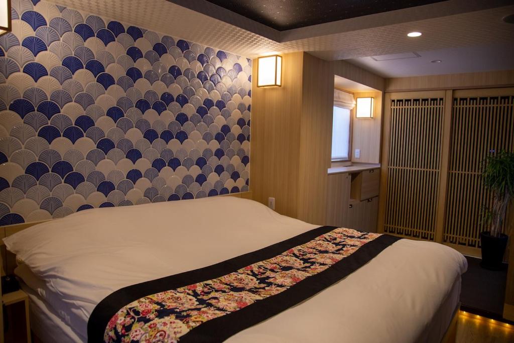 a bedroom with a bed with a patterned wall at Hotel Opera in Tokyo