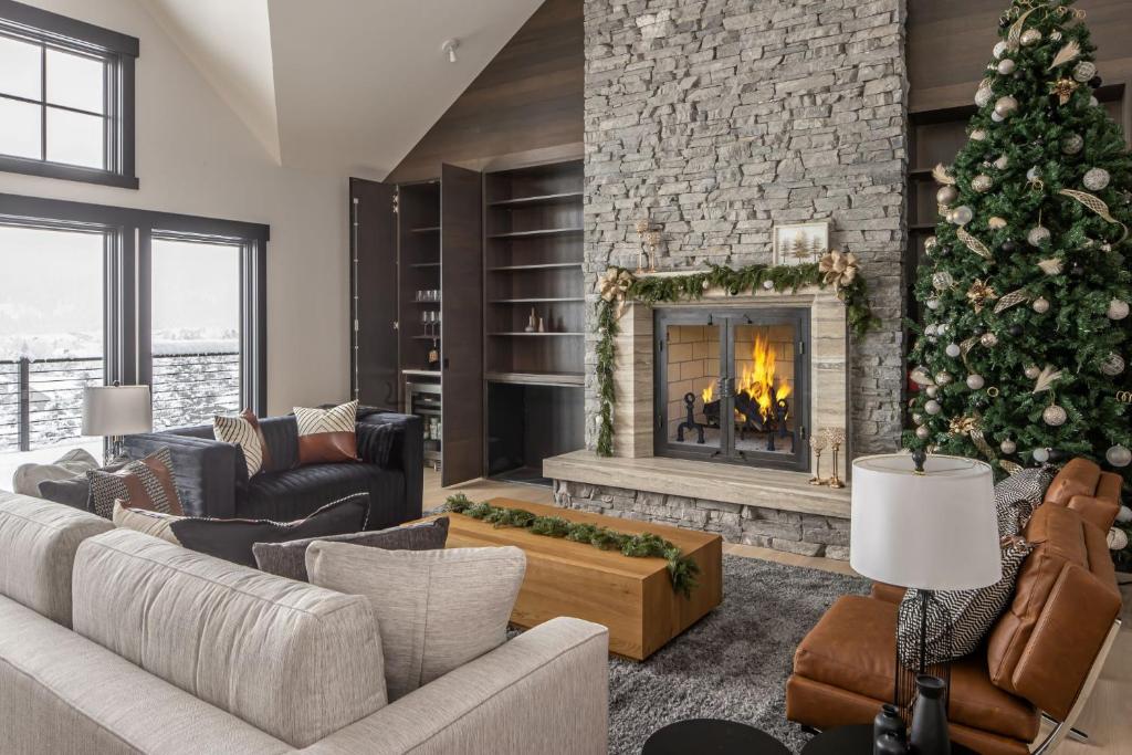 a living room with a christmas tree and a fireplace at 86 Moose Ridge in Big Sky