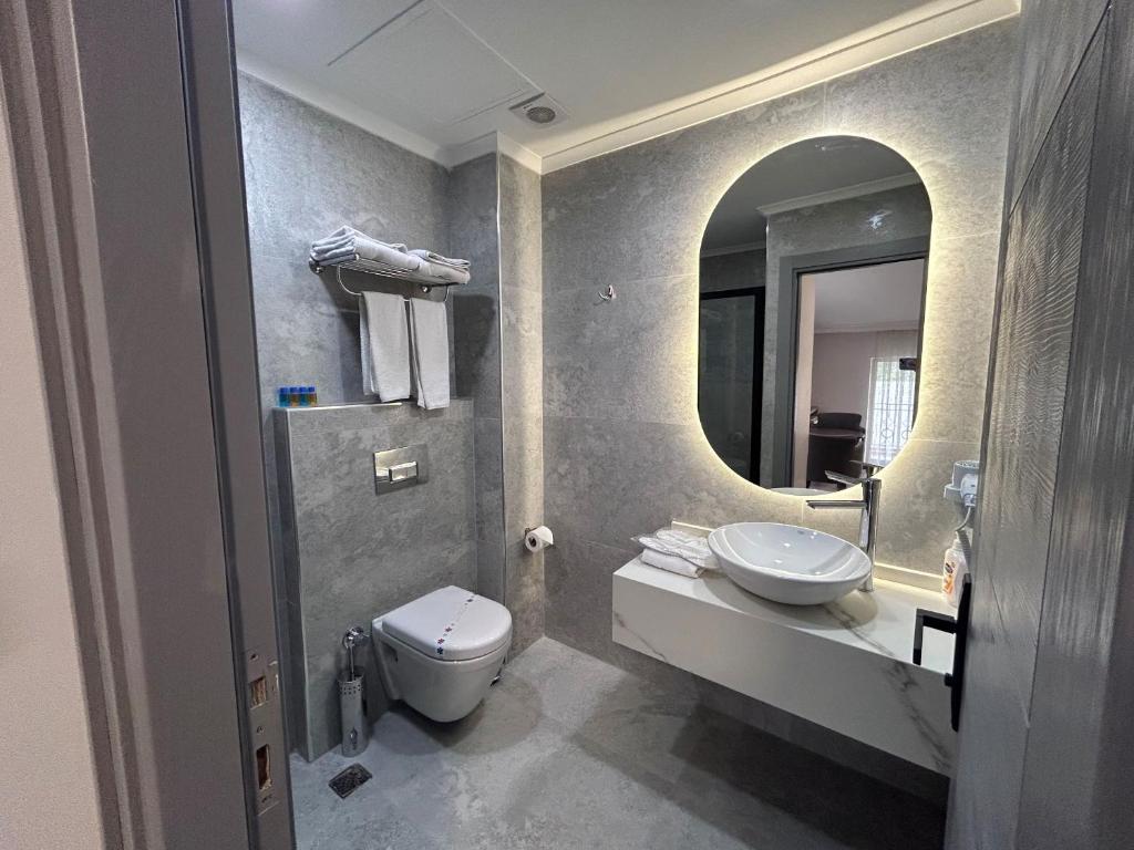 La salle de bains est pourvue de toilettes, d'un lavabo et d'un miroir. dans l'établissement Pendik Marine Hotel, à Istanbul