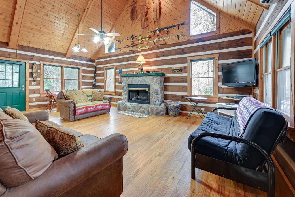 a living room with a couch and a fireplace at Rustic North Carolina Cabin with Fire Pit and Porch in Sylva