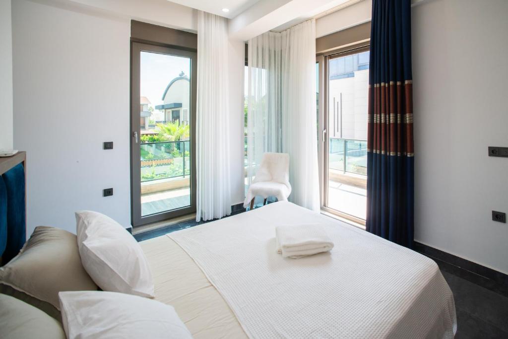 a bedroom with a white bed and a large window at Living Dream Villa HARMONY in Belek