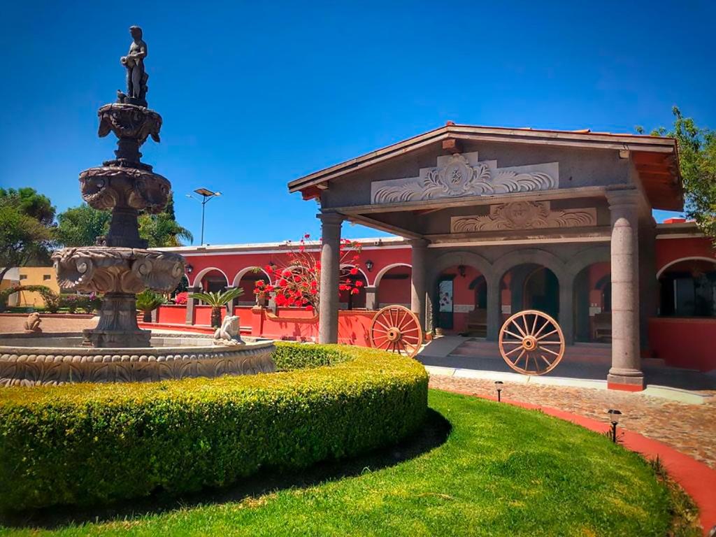 un edificio con una fuente frente a un parque en HOTEL & SPA HACIENDA TRES VIDAS, en Tequisquiapan