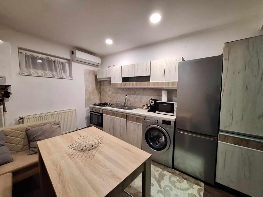 eine Küche mit einer Waschmaschine und einem Tisch im Zimmer in der Unterkunft Dominic house in Turda