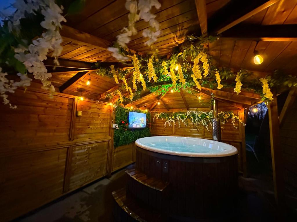 a bathroom with a tub in a wooden house at Dog Friendly Glamping Pods with Hot Tubs in Dwyran