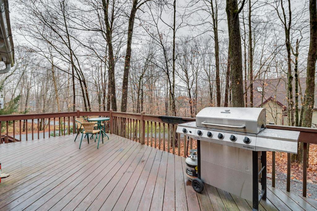Pocono LakeにあるFamily-Friendly Cabin with Fire Pit in Pocono Lake!の木製デッキ(ピクニックテーブル付)