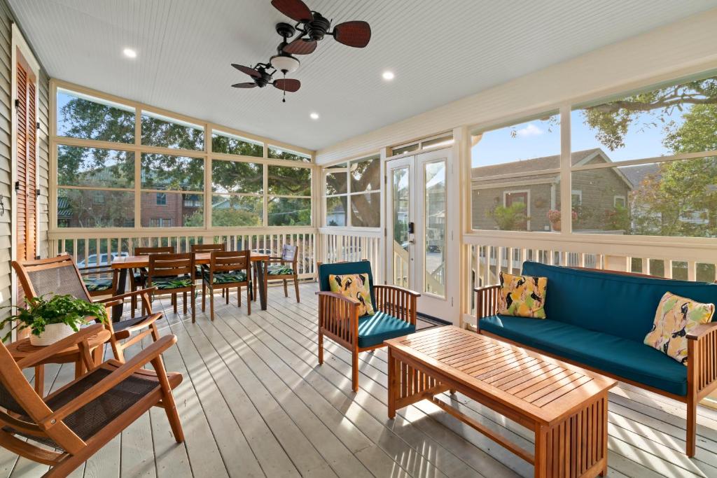 une véranda avec un canapé bleu, des tables et des chaises dans l'établissement Historic Galveston Family Beach Home With 3 King Beds, à Galveston