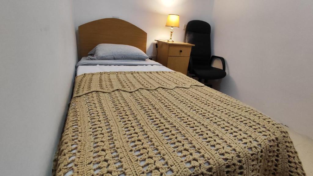 Un dormitorio con una cama con una manta. en Your room, en St Paul's Bay