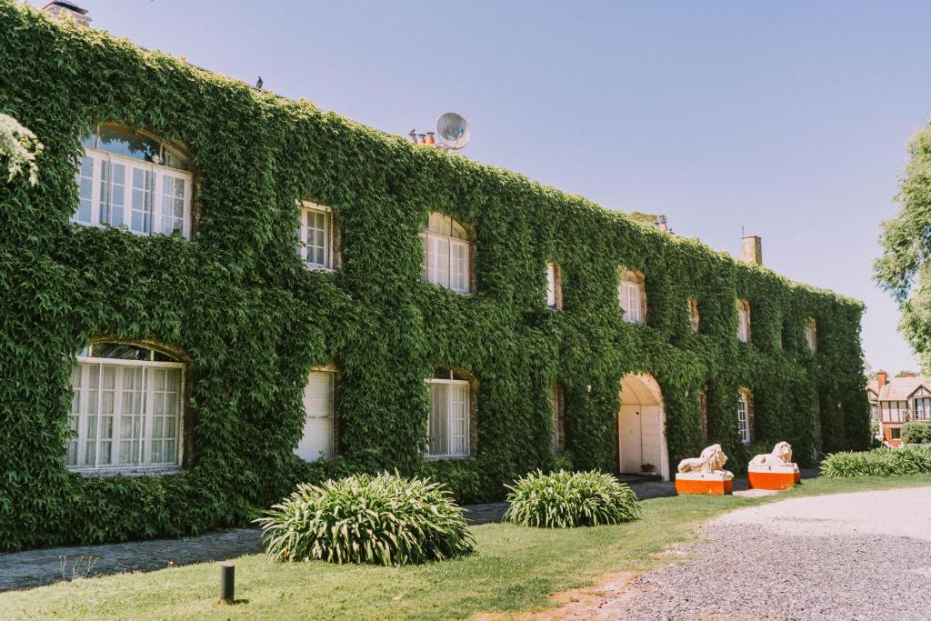 un edificio cubierto de hiedra con plantas delante de él en Hotel Apartur Mar del Plata en Mar del Plata