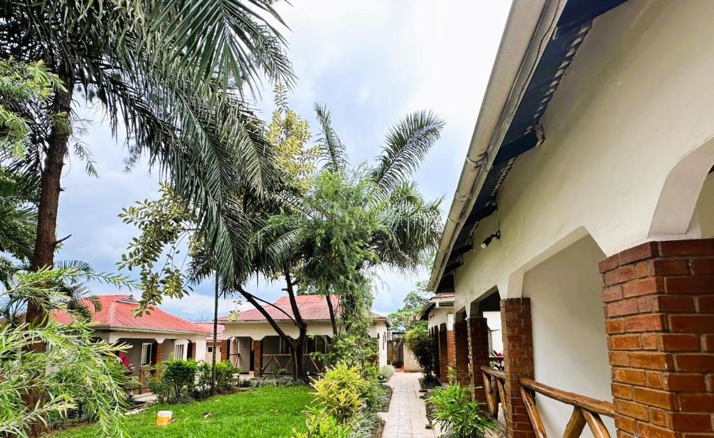 a house with palm trees next to a sidewalk at Home Feeling Neneu Lodge in Moshi