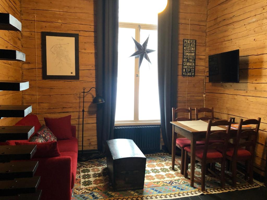 a living room with a red couch and a table at Stationmaster's studio in Porvoo