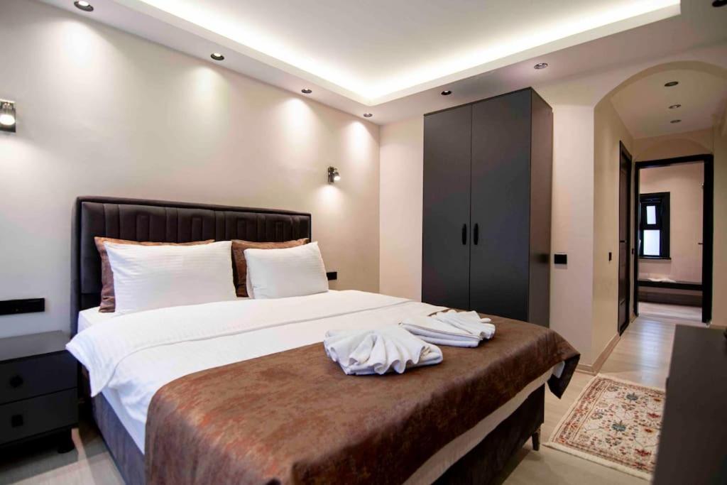 1 dormitorio con 1 cama grande con sábanas blancas en Cozy Stay with a Turkish bath,in heart of AyaSofia en Estambul