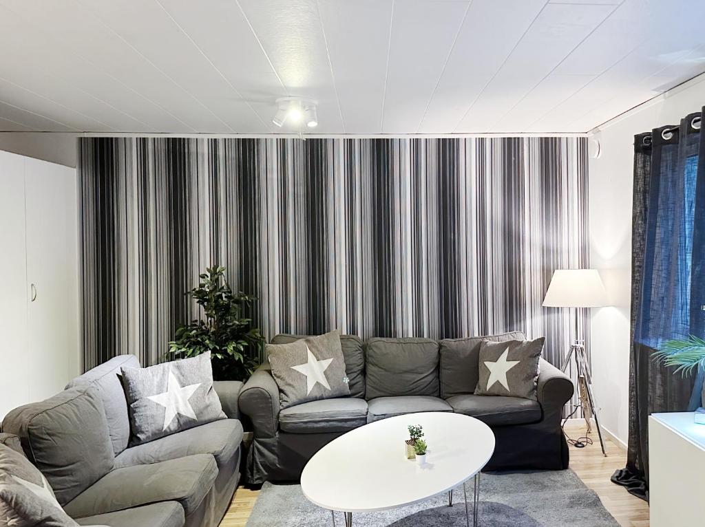 ein Wohnzimmer mit einem Sofa und einem Tisch in der Unterkunft Ystad Holiday Houses in Ystad