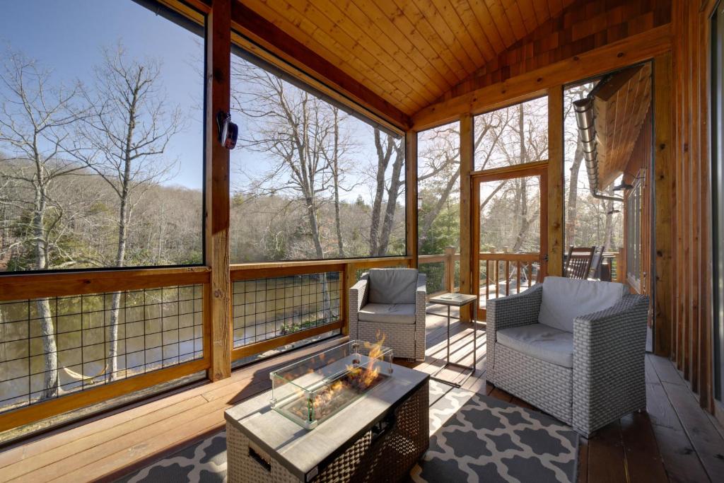 un porche cubierto con 2 sillas y una mesa en Spacious Glenville Home with Fire Pit and Lake Access, en Glenville