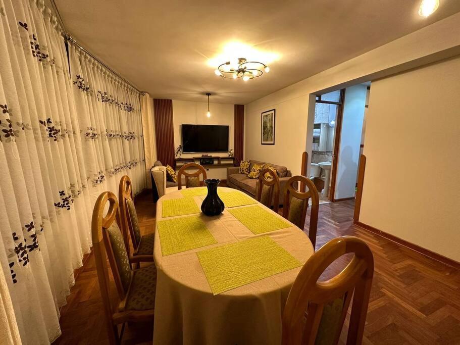 Lugar acogedor, céntrico:3H,WIFI في كوسكو: غرفة طعام مع طاولة مع إناء عليها