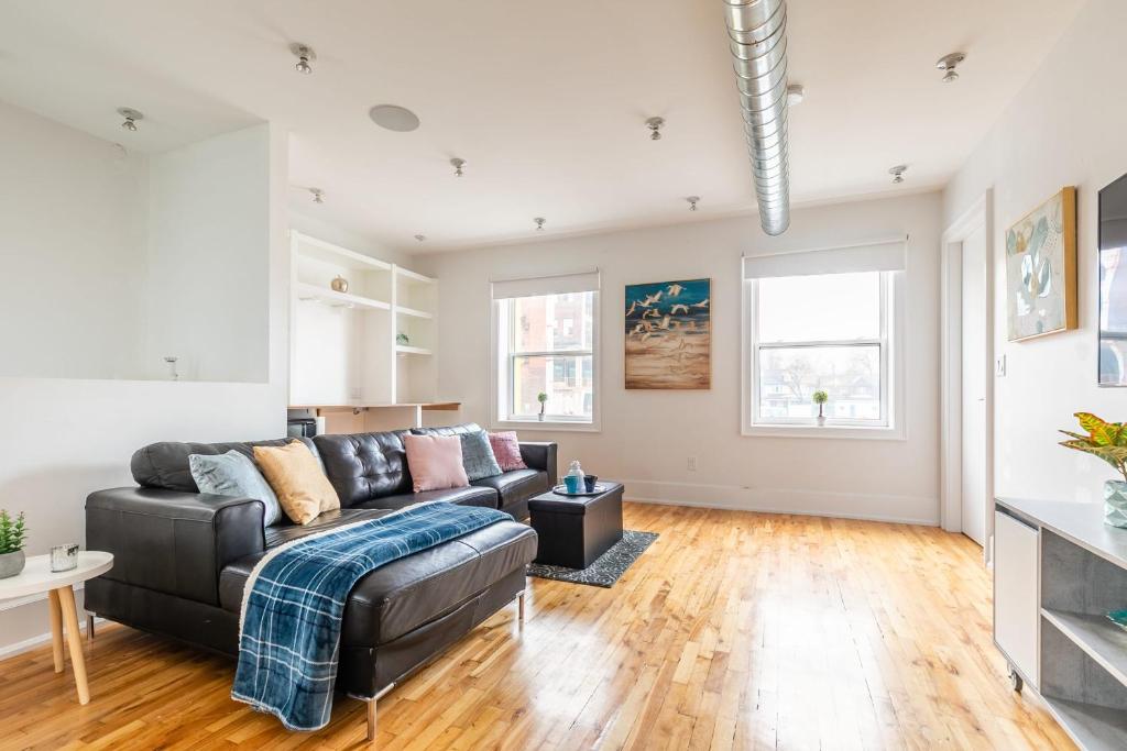 a living room with a couch and a table at Modern 2 BR Condo - Heart of Leslieville in Toronto