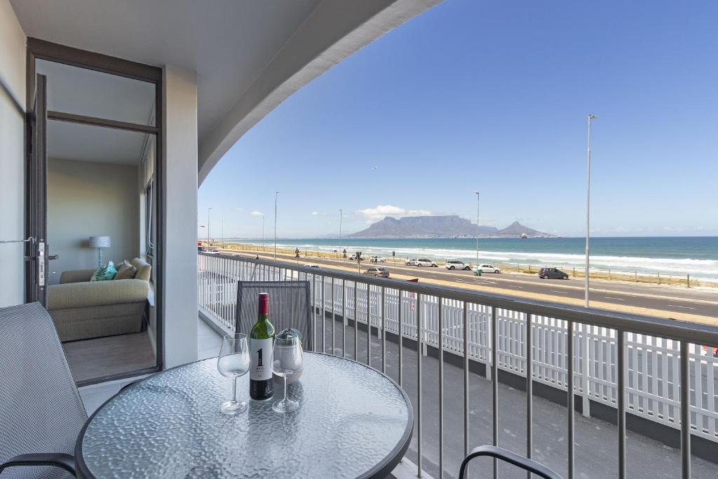 a balcony with a table and a view of the beach at Witsand 102 by HostAgents in Bloubergstrand