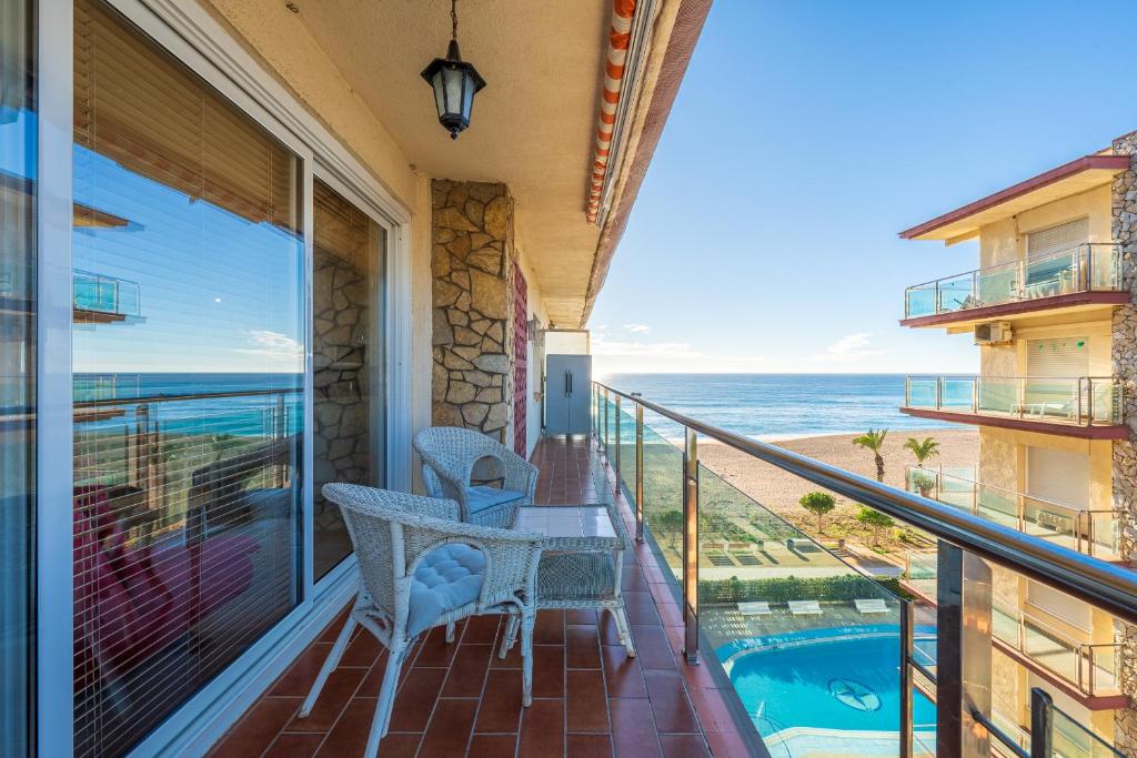 a balcony with a table and chairs and a view of the ocean at Hauzify I Apartament Llevant in Santa Susanna